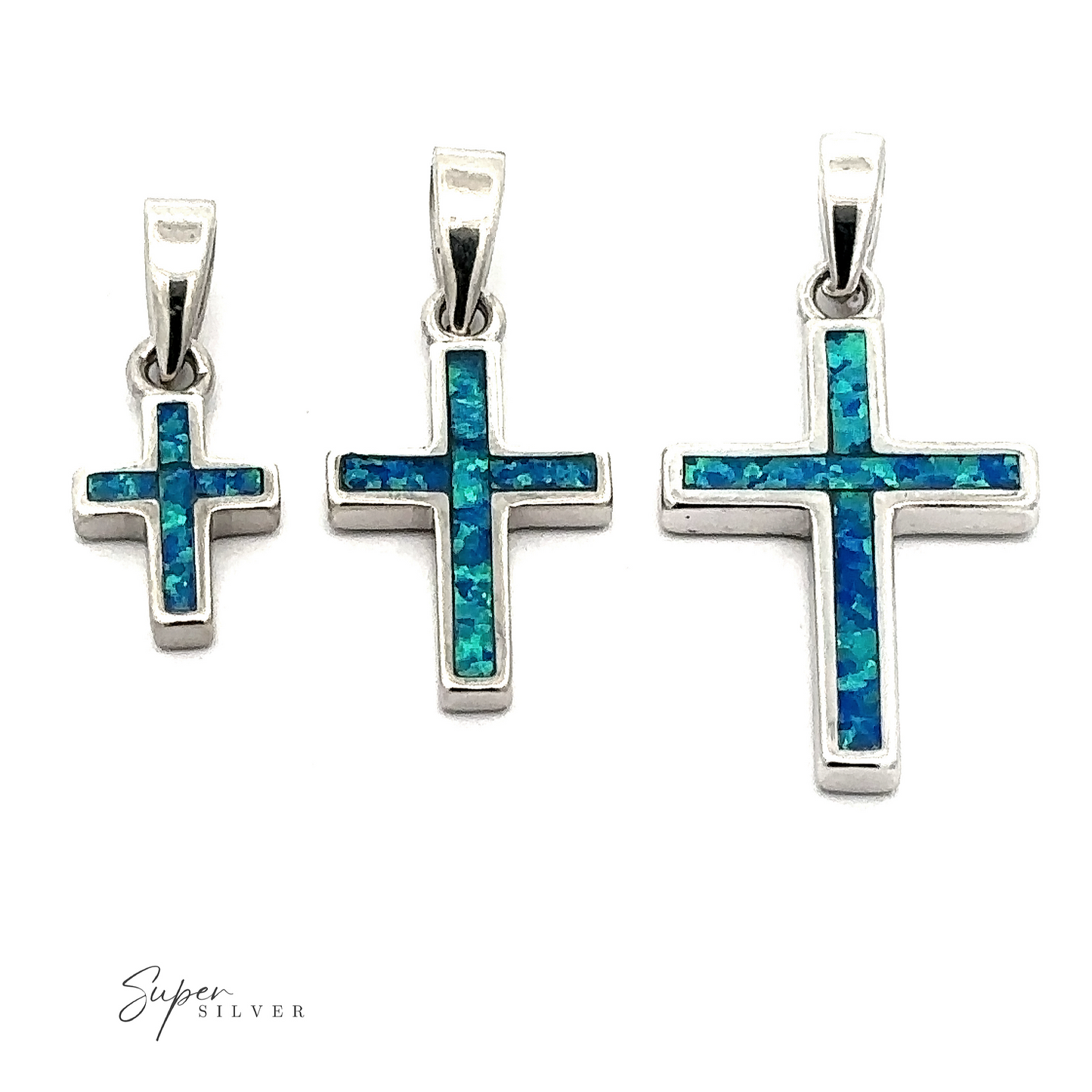 
                  
                    The Lab-Created Opal Cross Pendants in sterling silver beautifully showcase a captivating blue-green opal inlay, artistically set against a white background.
                  
                