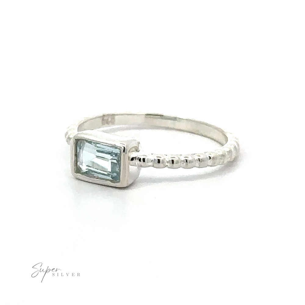 
                  
                    Silver Ring with a Rectangular Gemstone on a Plain Background.
                  
                