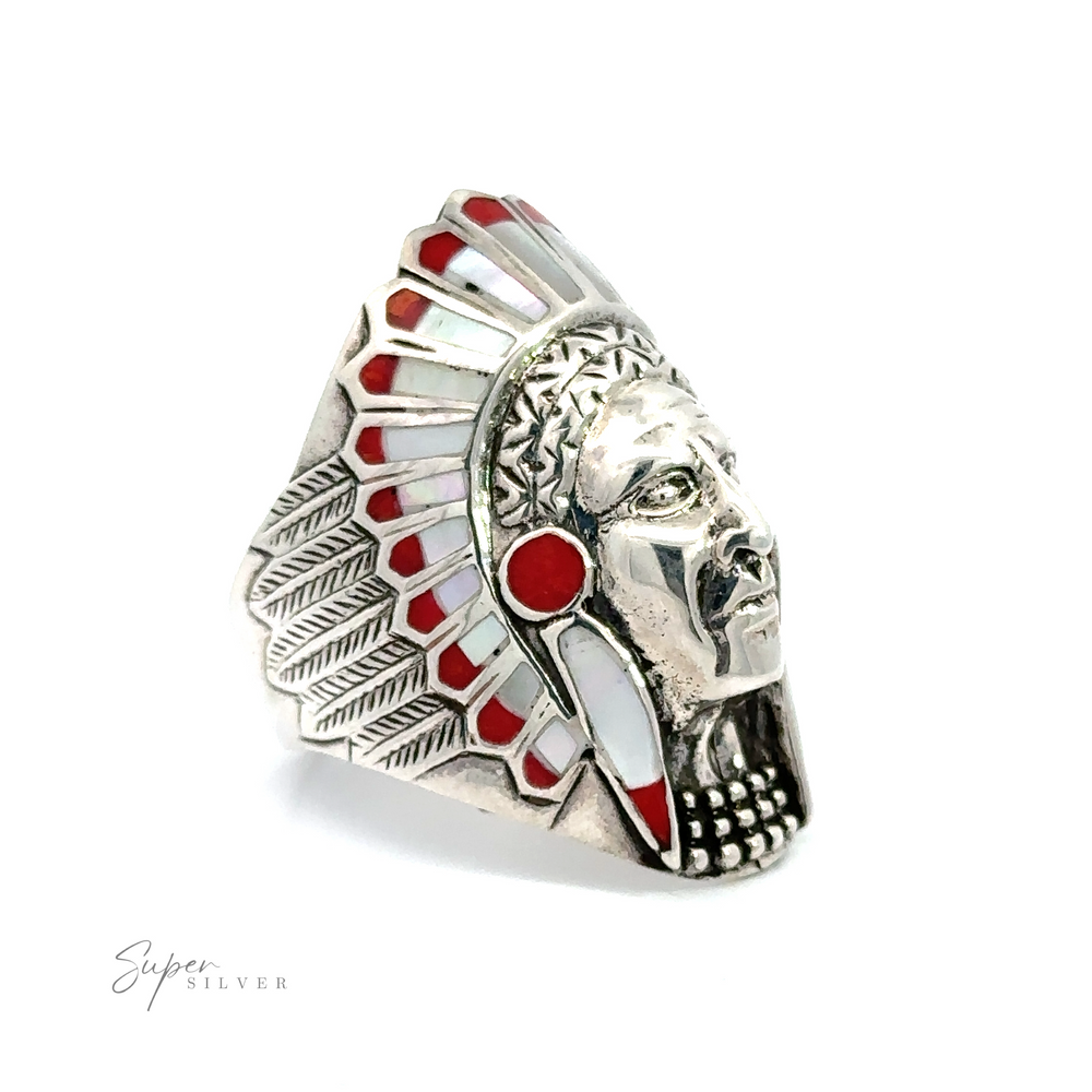 
                  
                    An Inlay Chief Ring with red and white stones, adorned in a traditional headdress.
                  
                