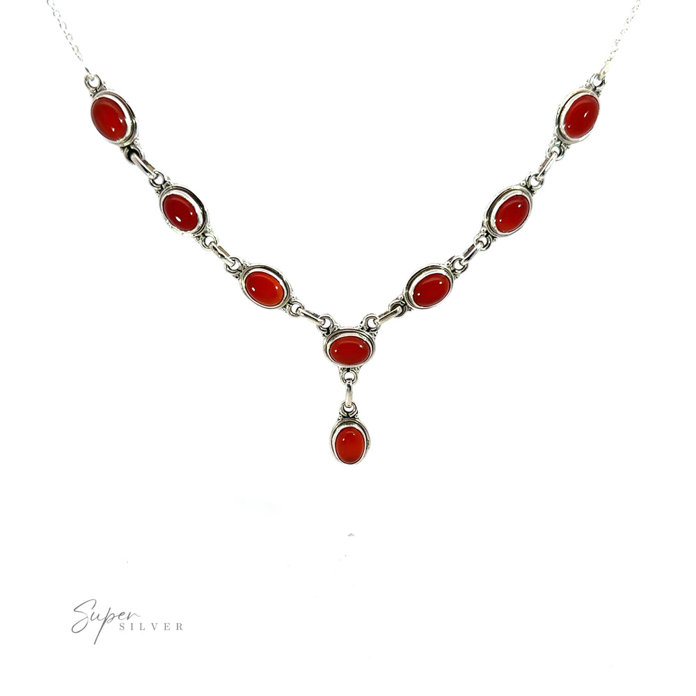 
                  
                    A Simple Oval Y Necklace with Gemstones with red oval gemstones set in silver on a white background, featuring a bohemian charm with a Y-shaped drop pendant. "Super Silver" text is displayed in the lower left corner.
                  
                
