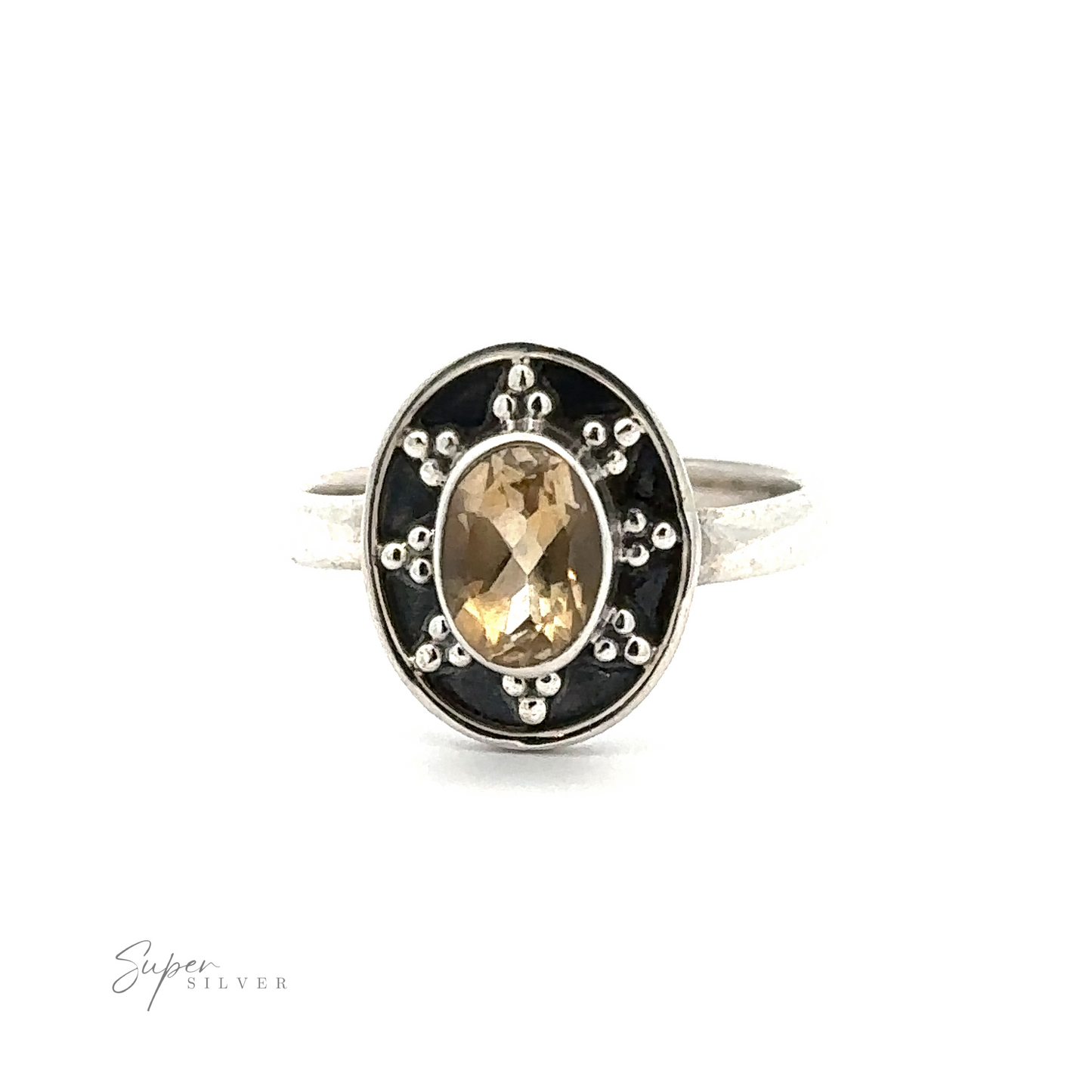 
                  
                    An Oval Gemstone Ring with Ball and Disk Border featuring an oval-cut yellow gemstone set in a decorative, black-bordered setting with dot accents, labeled "Super Silver" at the bottom. This vintage-inspired jewelry piece exudes timeless elegance and charm.
                  
                