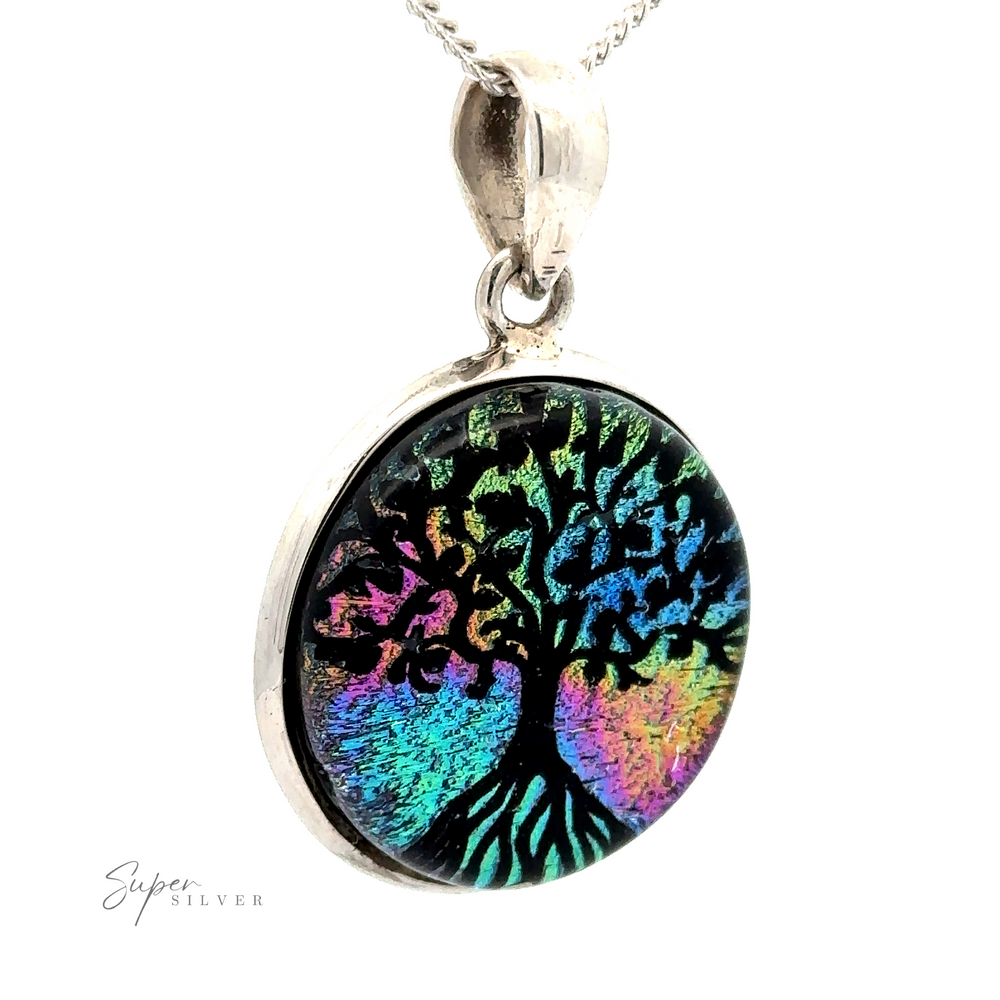 
                  
                    A round, sterling silver Dichroic Glass Tree Of Life Pendant with a rainbow-colored tree design on a dark background, hanging from a silver chain.
                  
                