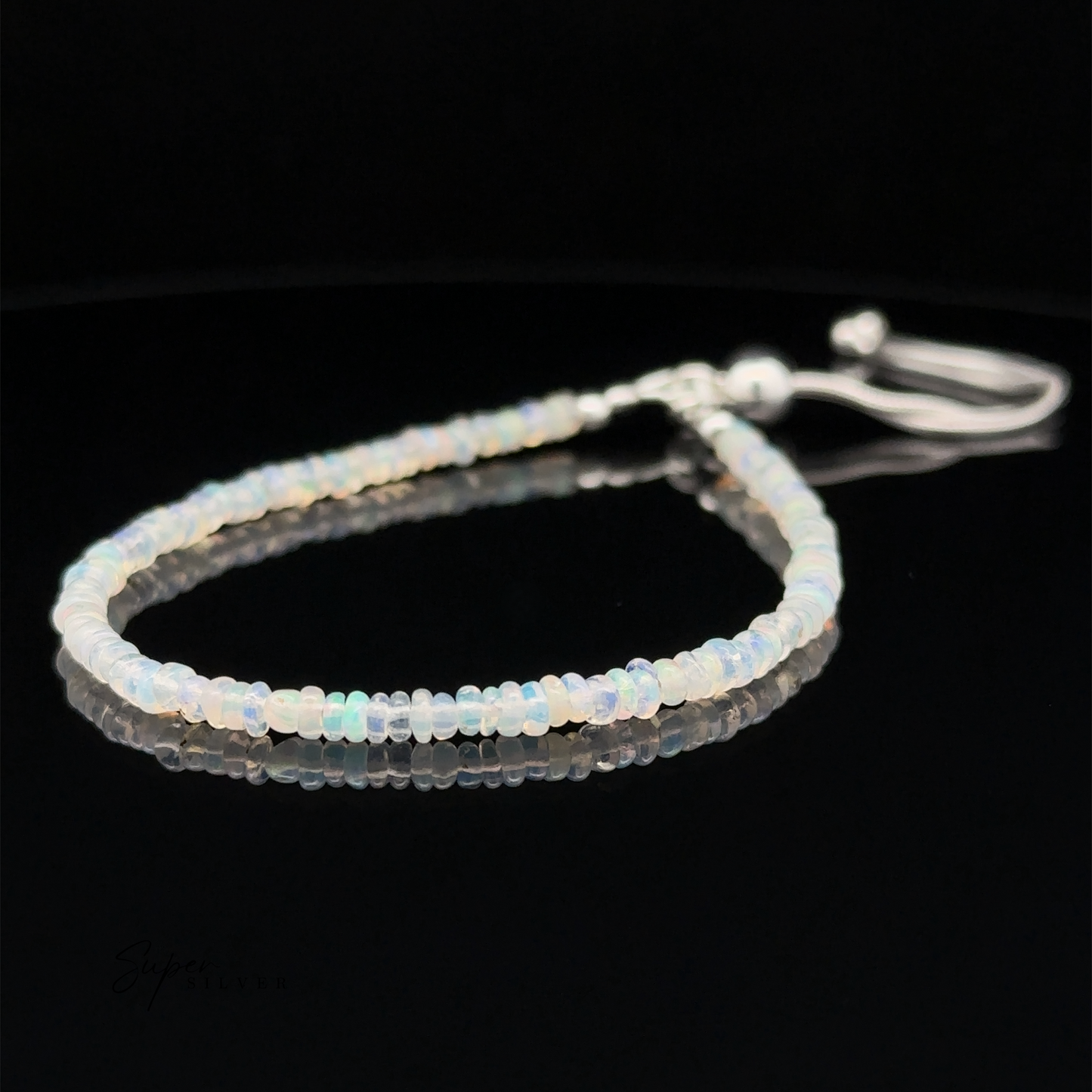 
                  
                    An Ethiopian Opal Beaded Bracelet with a sliding clasp, displayed on a black reflective surface. This beaded bracelet features an adjustable length closure for the perfect fit.
                  
                