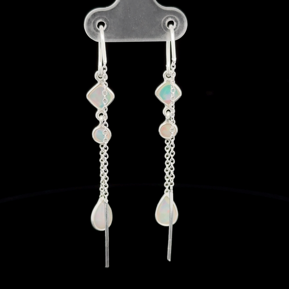 
                  
                    A pair of elegant, long Ethiopian Opal Threader Earrings with multiple geometric stones and chain links, displayed on a clear holder against a black background.
                  
                