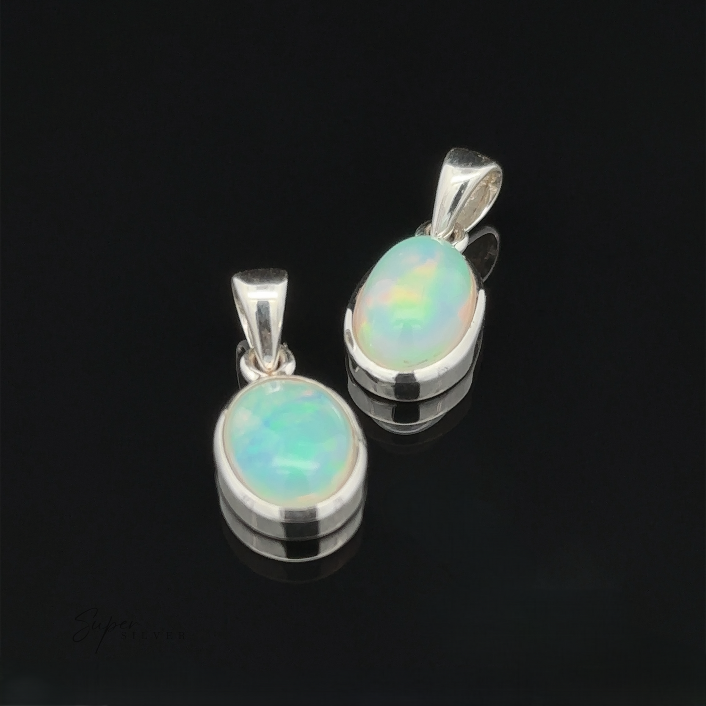 
                  
                    The Oval Ethiopian Opal Pendant charms, crafted in sterling silver, showcase a minimalist style against a black background.
                  
                