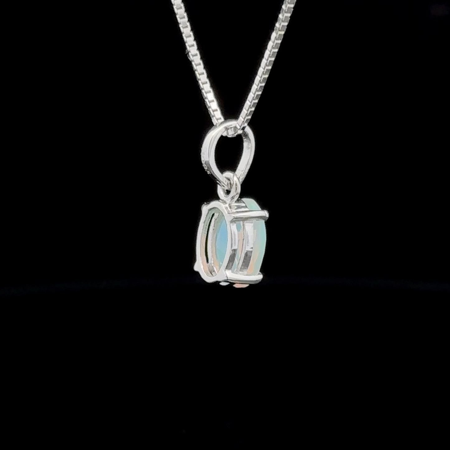 
                  
                    This sterling silver necklace showcases a minimalist pendant with an oval design, featuring an Ethiopian opal set against a black background.
                  
                