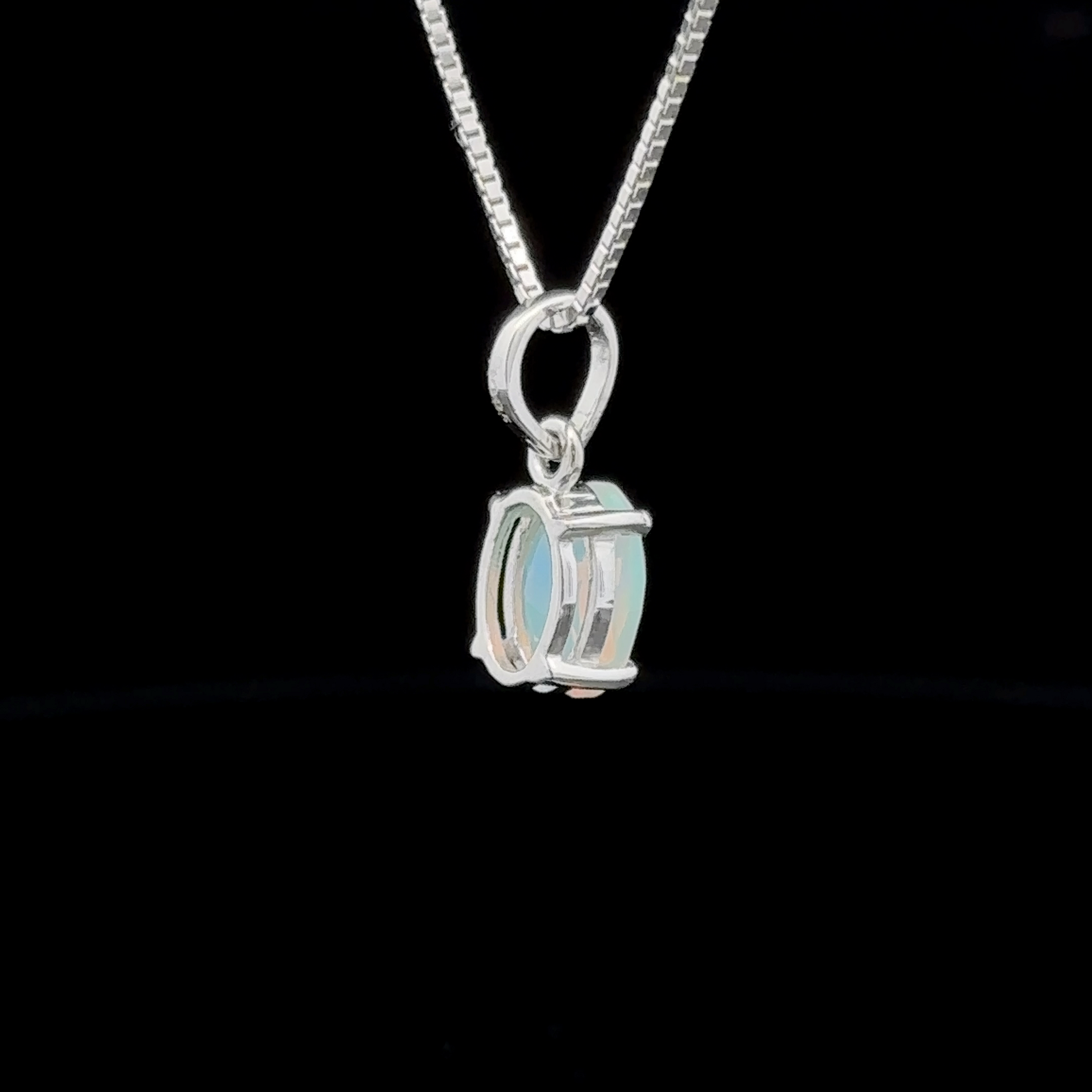 This sterling silver necklace showcases a minimalist pendant with an oval design, featuring an Ethiopian opal set against a black background.