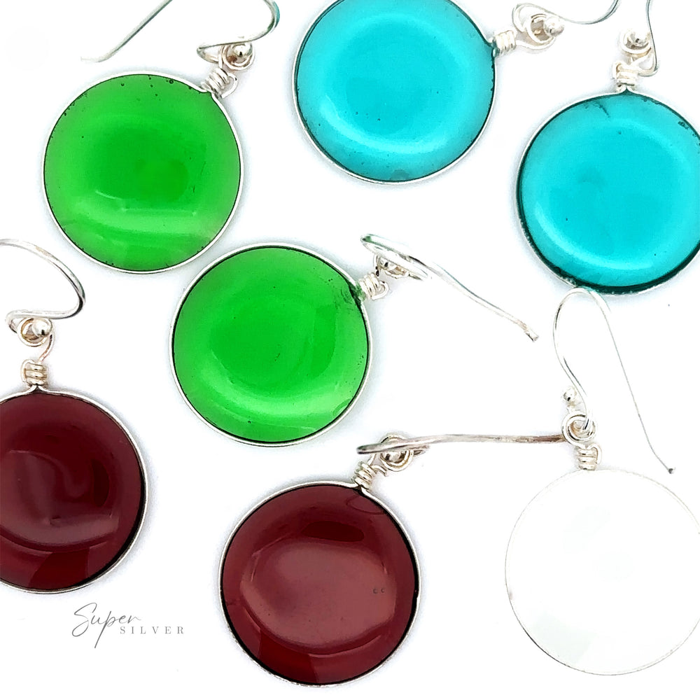 Image features Round Glass Earrings, a simple set of several pairs of round, colored glass earrings in green, blue, red, and white on a white background. The earrings have .925 Sterling Silver hooks and a glossy finish.