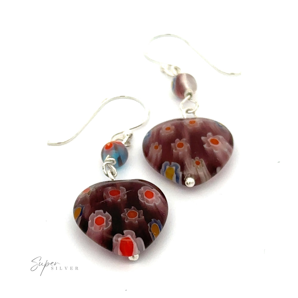 A pair of Beaded Resin Floral Heart Earrings with multicolor flower detail and silver hooks. These .925 Sterling Silver earrings feature vibrant colors including red, blue, yellow, and white.