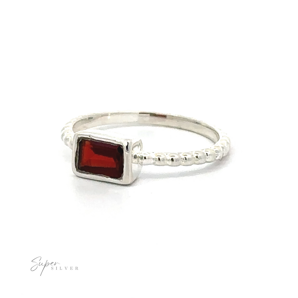 
                  
                    Rectangular Gemstone Ring with Beaded Band with a rectangular red gemstone on a white background.
                  
                
