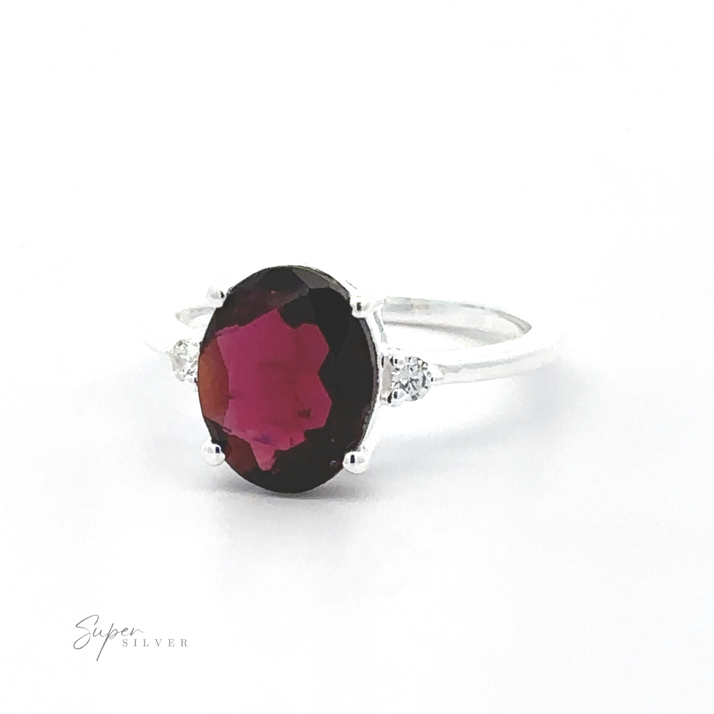 
                  
                    Brilliant Pronged Oval Gemstone Ring with a large oval garnet in a prong setting, flanked by two small diamonds, displayed against a white background.
                  
                