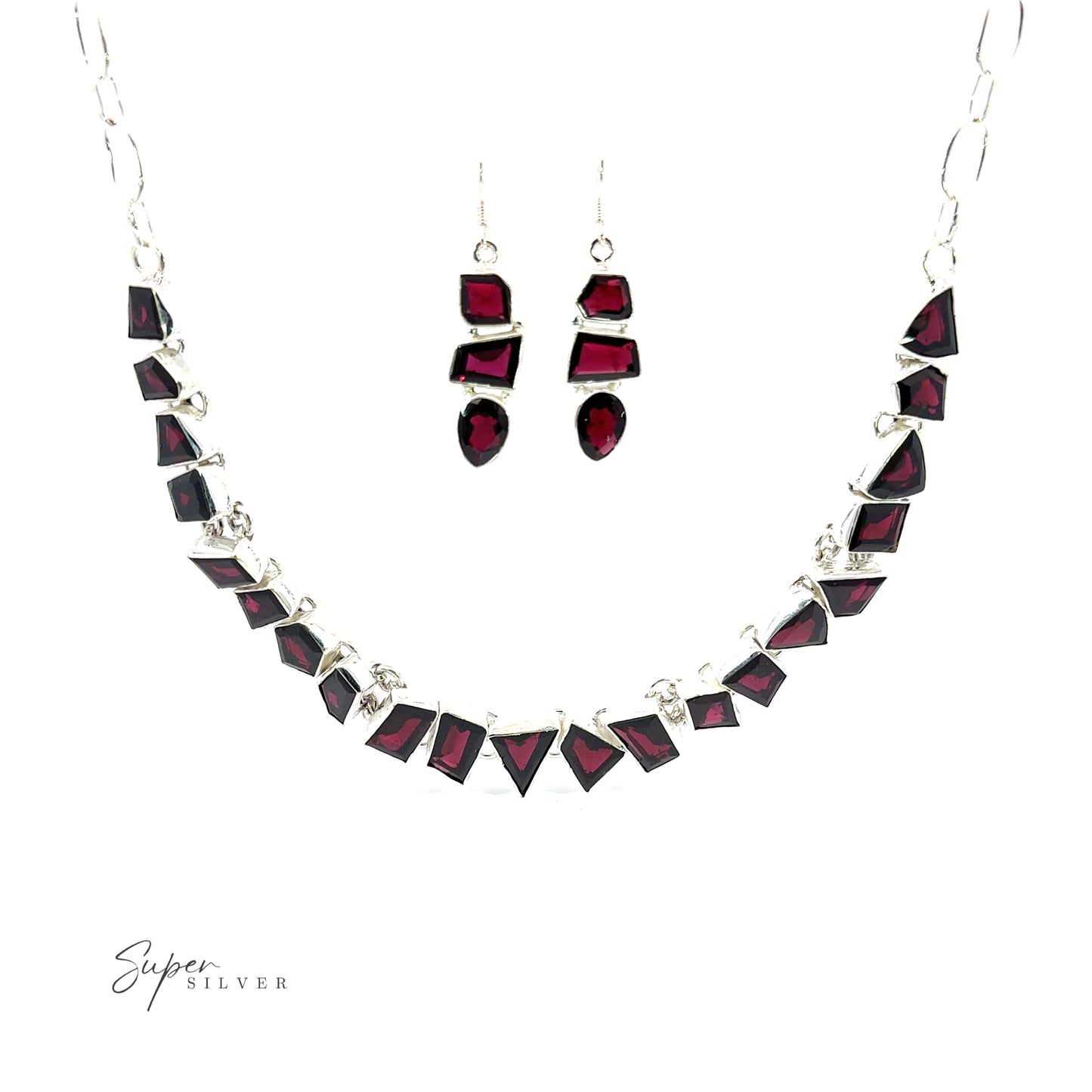 
                  
                    A Statement Gemstone Necklace and a pair of earrings with rich garnet stones set in silver, displayed on a white background. The necklace features geometric-shaped gemstones, and the earrings have a matching design, creating an elegant coordinated set.
                  
                