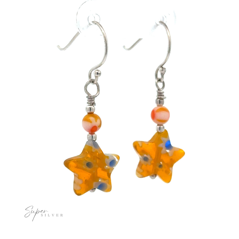 
                  
                    A pair of Resin Beaded Yellow Star Earrings featuring orange beads with additional small orange, clear, and yellow beads above, attached to sterling silver hooks.
                  
                