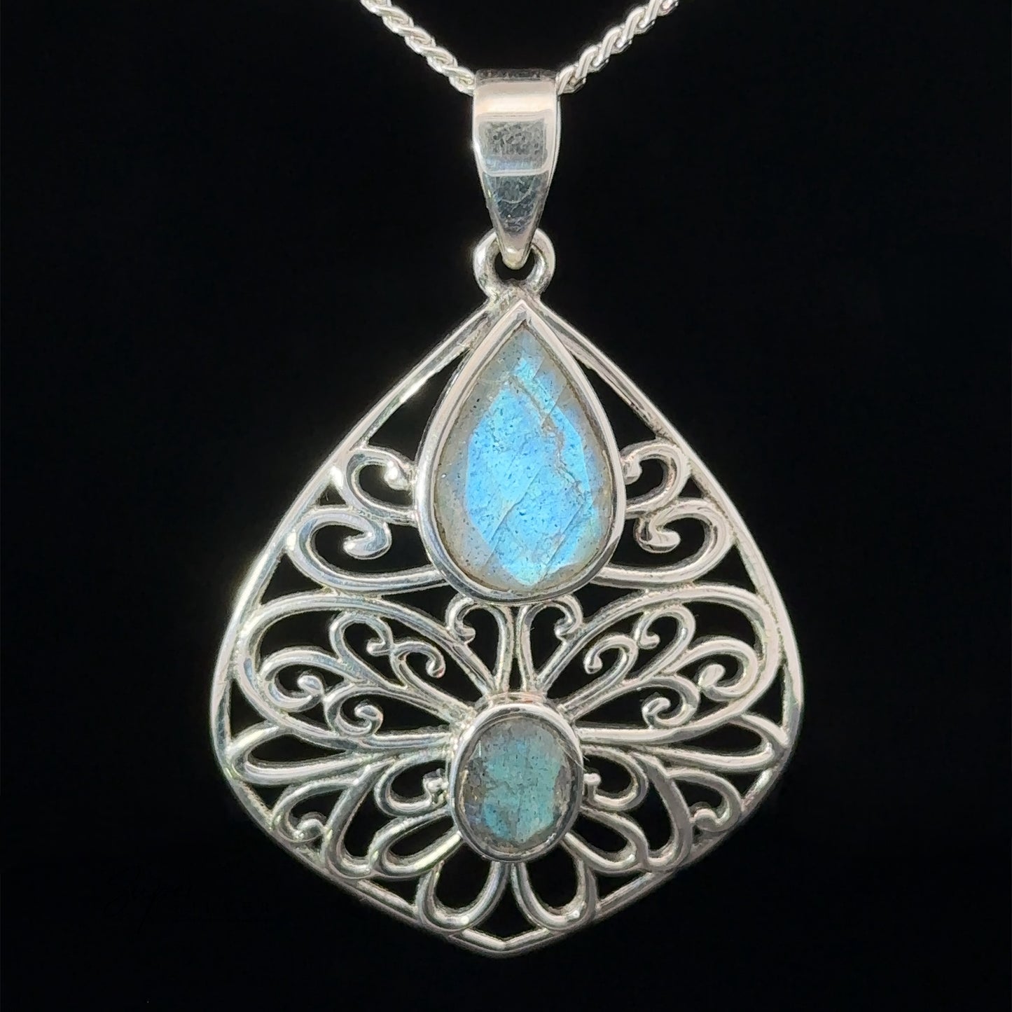 
                  
                    Teardrop Filigree Gemstone Pendants with an ornate sterling silver design featuring two iridescent blue stones.
                  
                