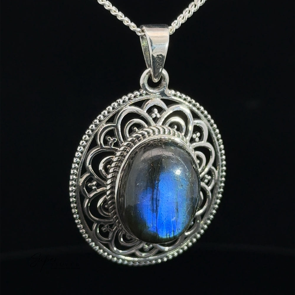 An Oval Stone Pendant with Filigree Border featuring an ornate design with a central oval-shaped blue gemstone, hanging from a silver chain.