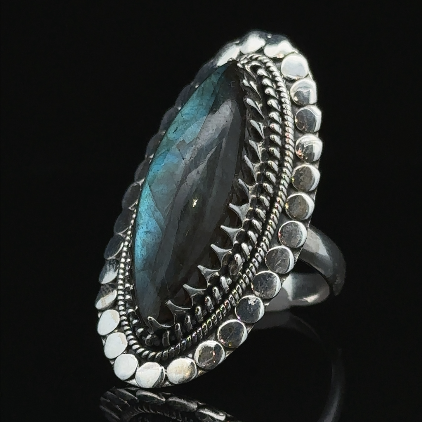 
                  
                    A Statement Marquise Shaped Gemstone Ring, featuring a beaded and ornate border, set against a black background.
                  
                