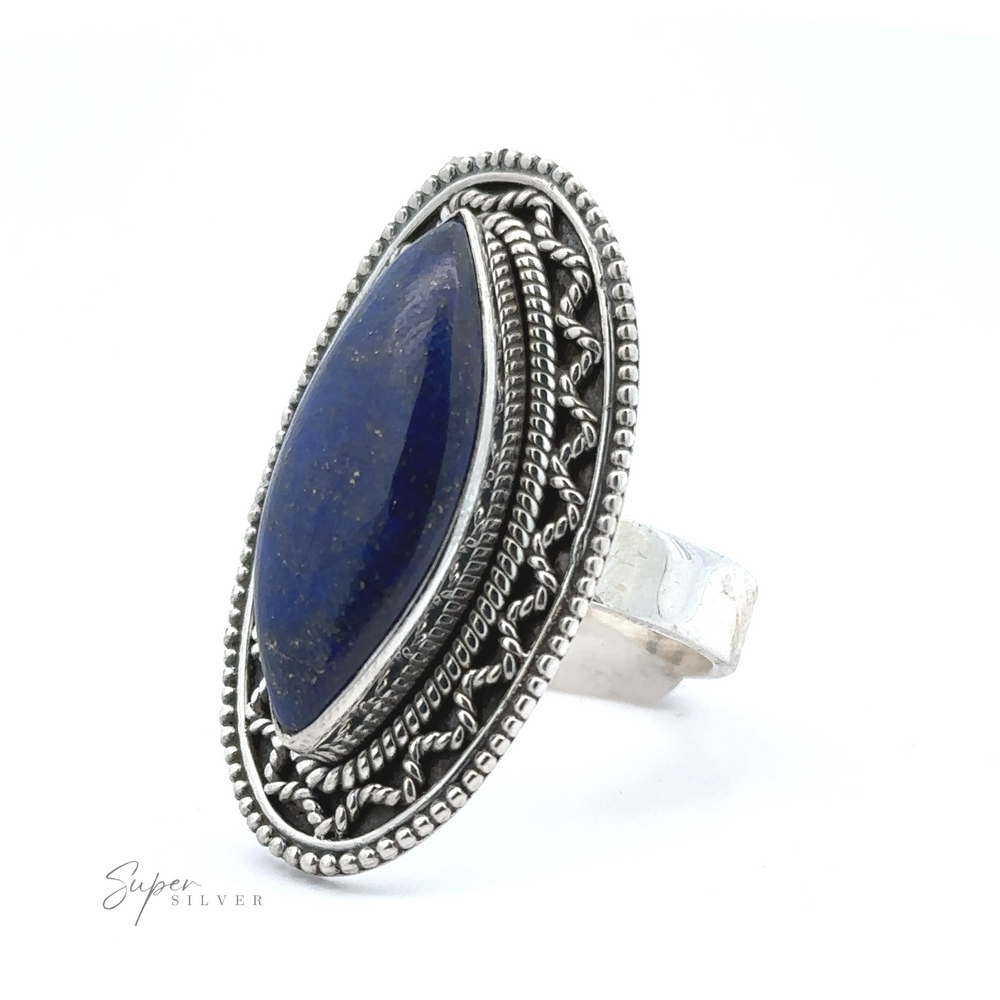 
                  
                    An ornate sterling silver ring featuring an elongated, deep blue stone with decorative metalwork around the setting in a bohemian twist. The words "Marquise Shaped Gemstone Ring With Vintage Shield Border" are visible on the bottom left.
                  
                