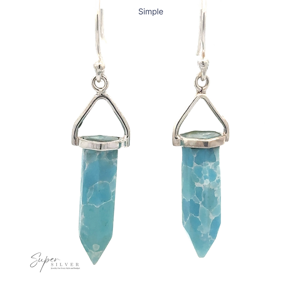 
                  
                    Pair of Obelisk Shape Raw Larimar Earrings featuring blue, faceted crystal pendants and elegant french hooks.
                  
                