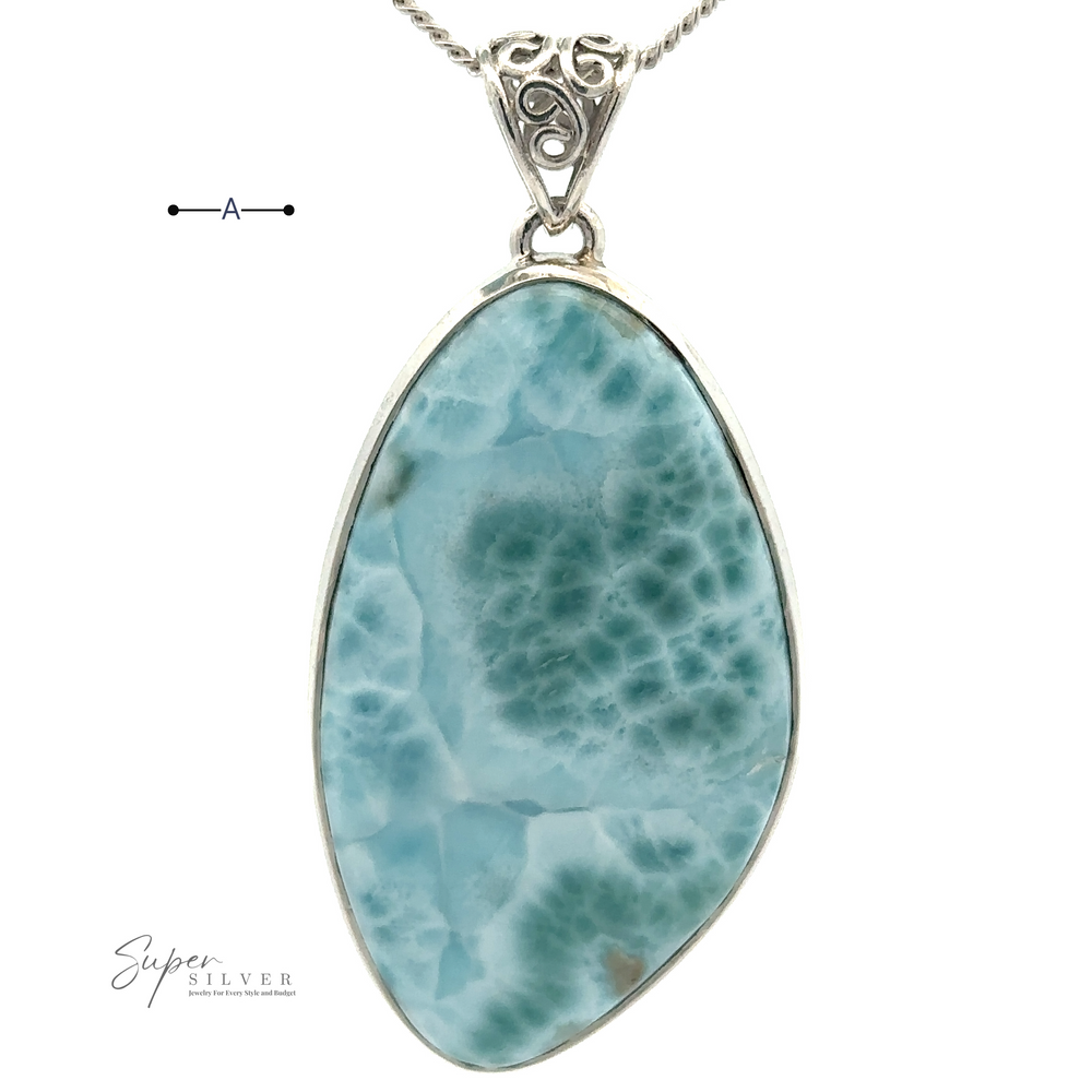 
                  
                    A Freeform Large Larimar Pendant featuring a large, polished blue-green larimar stone set in a sterling silver frame hangs on a chain.
                  
                