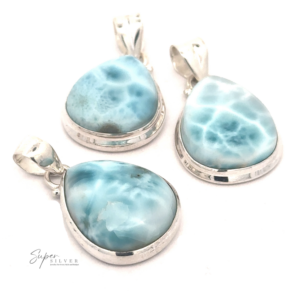 Three Small Teardrop Larimar Pendants each feature a light blue Larimar gemstone with unique marbling patterns. Perfect for a night out, the pendants are arranged on a white background.