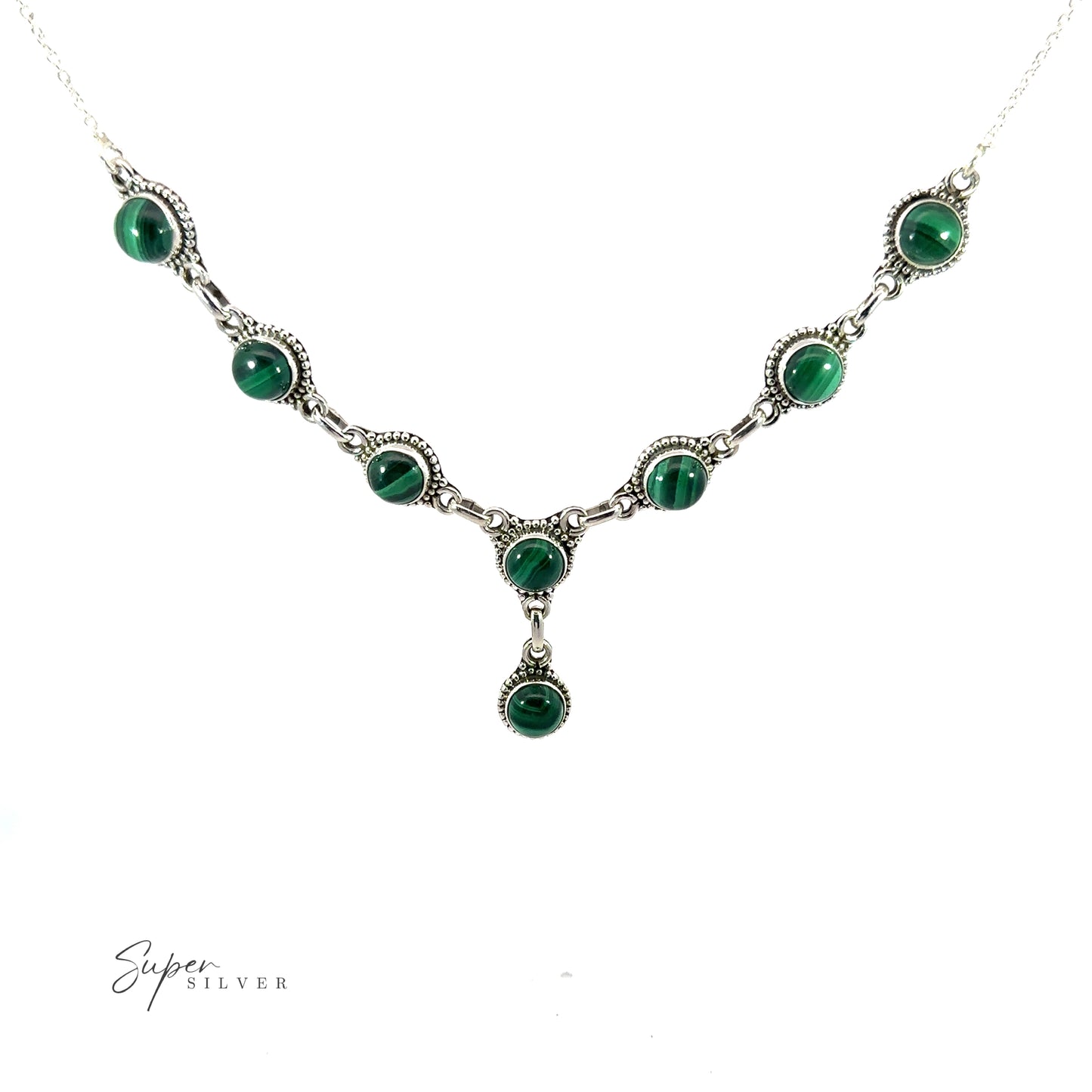 
                  
                    A Round Gemstone Y Necklace with Ball Border featuring nine circular green stones with a central stone hanging below the main chain. Perfect for those who love bohemian style jewelry, this piece adds a touch of elegance to any outfit. The background is white.
                  
                