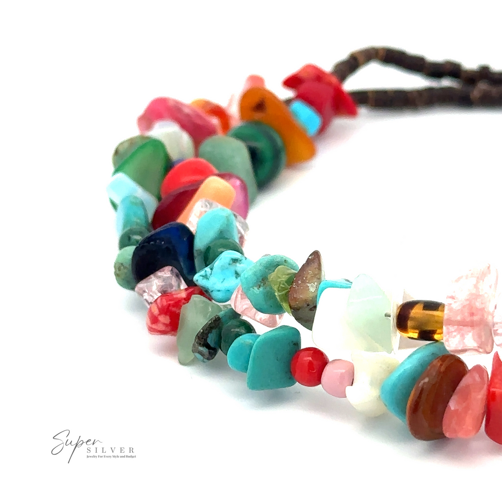 
                  
                    Close-up of a  Colorful Southwest Beaded Stone Anklet with stones of various shapes and colors, including turquoise, red, pink, and green. The "Super Silver" logo is visible in the bottom left corner.
                  
                