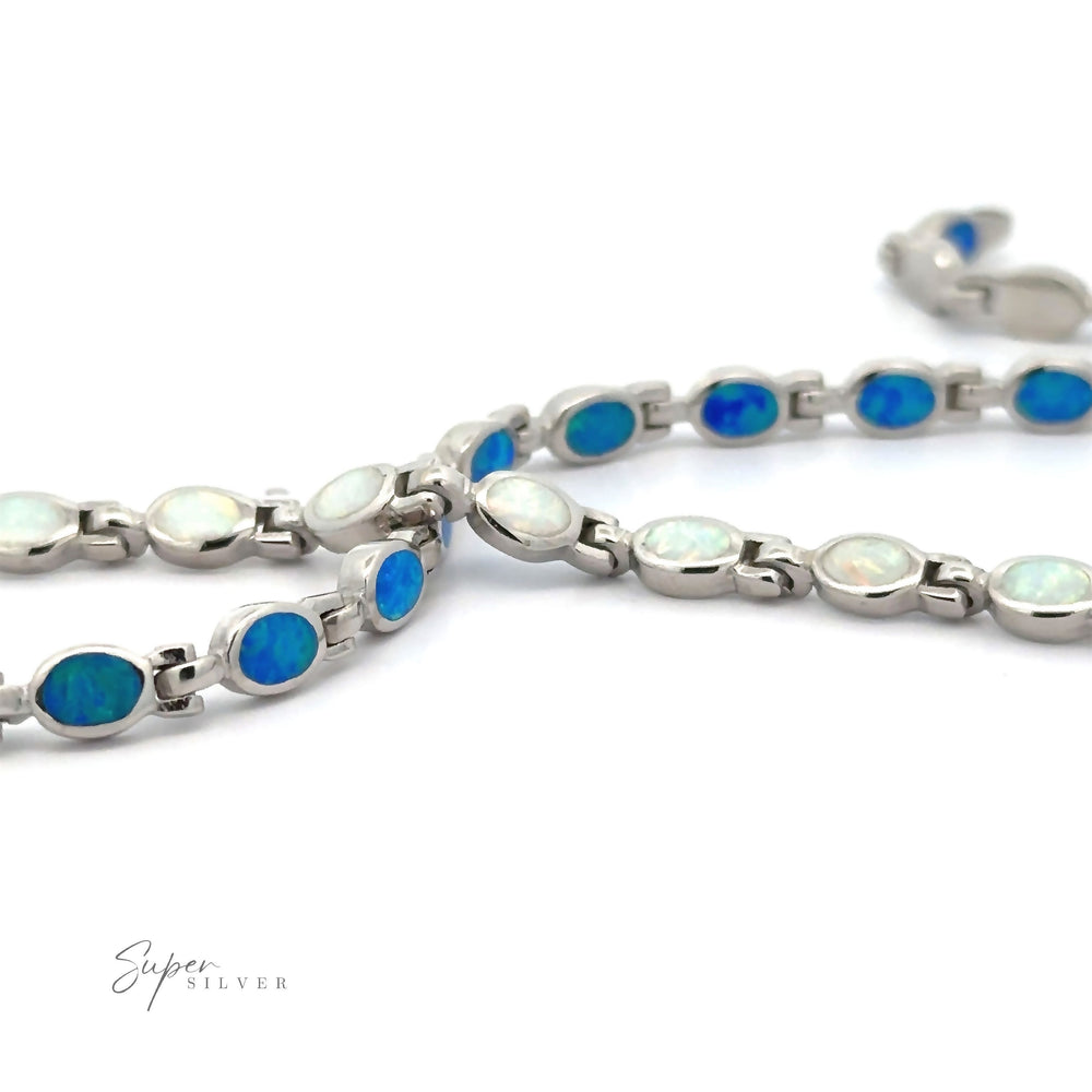 Oval Lab-Created Opal Bracelet with alternating blue and white gemstones on a white background. The word 