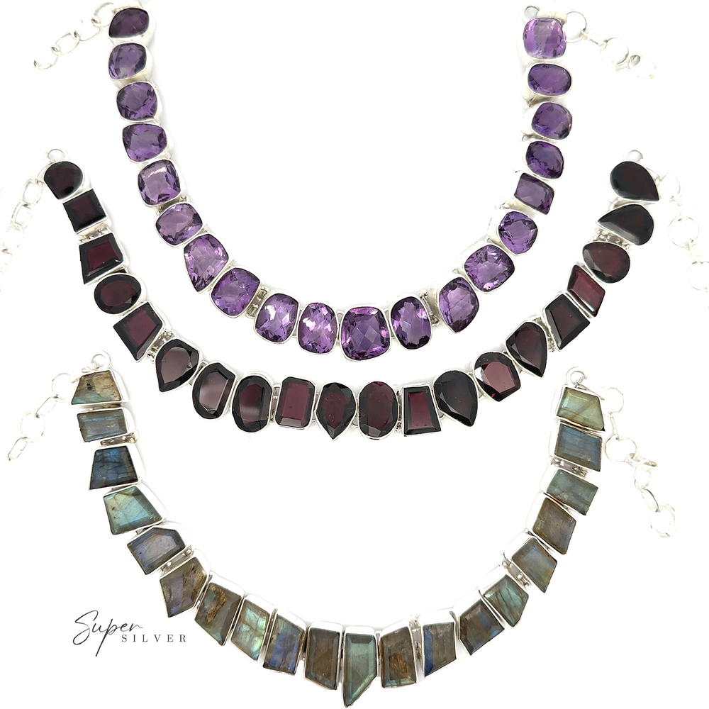 
                  
                    Three stone necklaces are displayed on a white background. The top one features amethyst stones, the middle one has dark red garnets, and the bottom one contains greenish stones. Text reads "Statement Gemstone Necklace." This exquisite gemstone necklace collection radiates elegance and charm.
                  
                