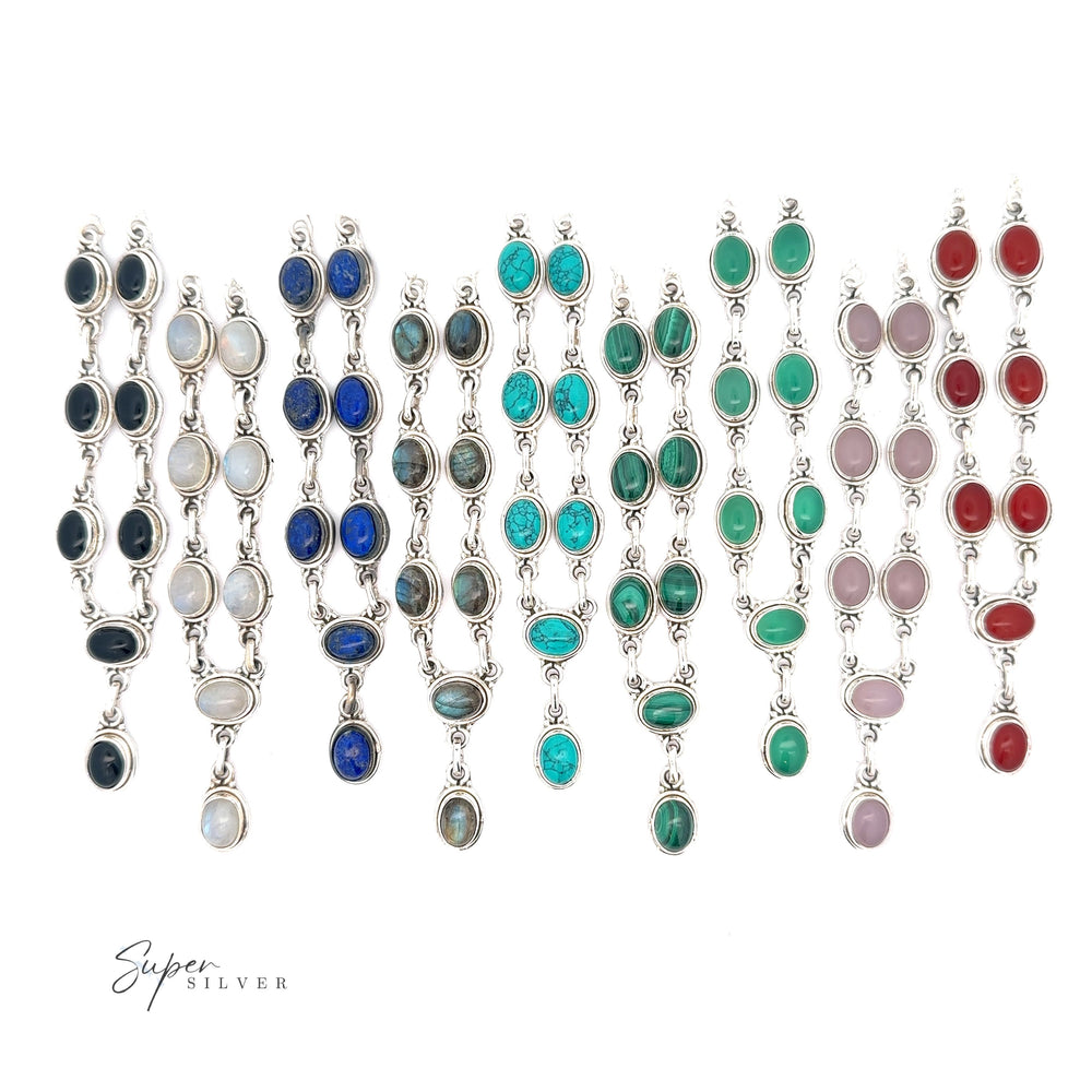
                  
                    A display of multiple pairs of Simple Oval Y Necklace with Gemstones featuring various colored oval gemstones set in silver, exuding bohemian charm. Arranged in neat rows on a white background with the text "Super Silver" in the corner.
                  
                