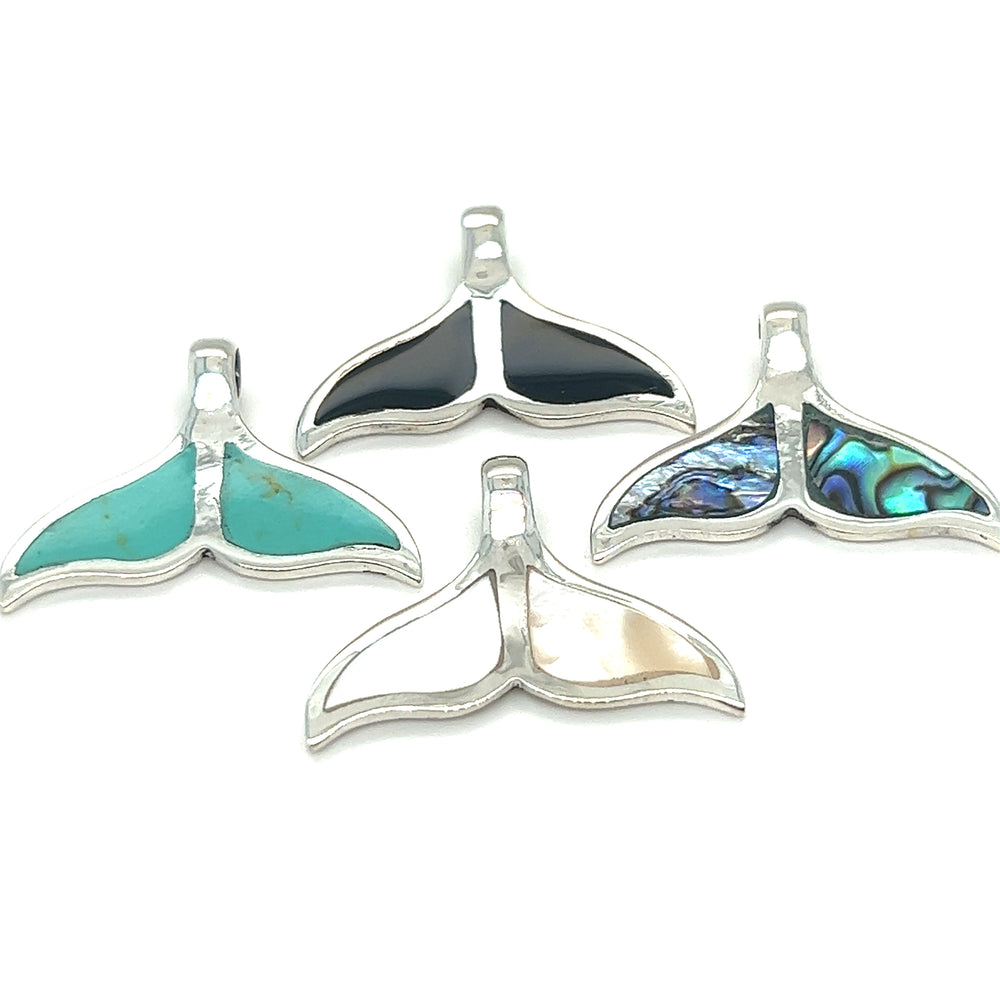 A set of four ocean-themed Inlay Whale Tail Pendants crafted in sterling silver by Super Silver.