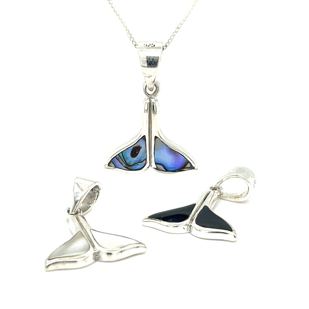 A pair of simple whale tail pendants and earrings with ocean conservation inlaid stone options.