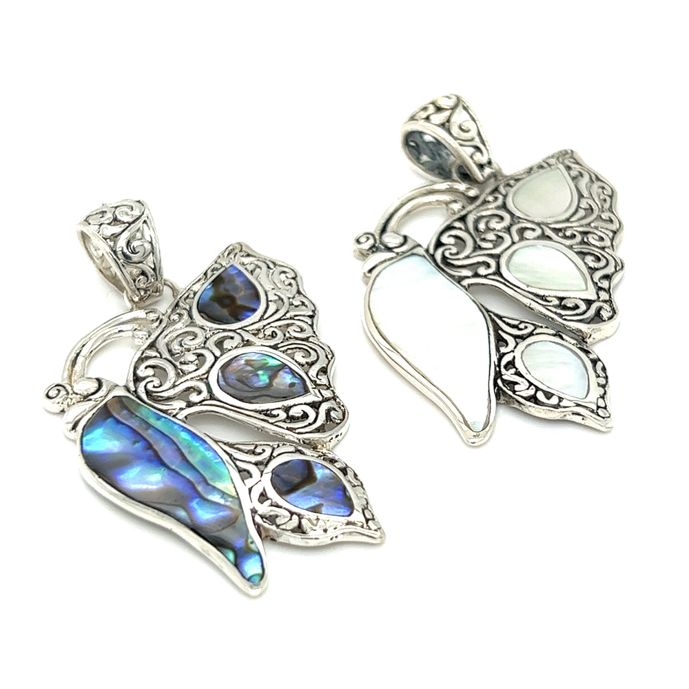 Two silver Filigree Butterfly Inlay pendants with abalone symbolism.