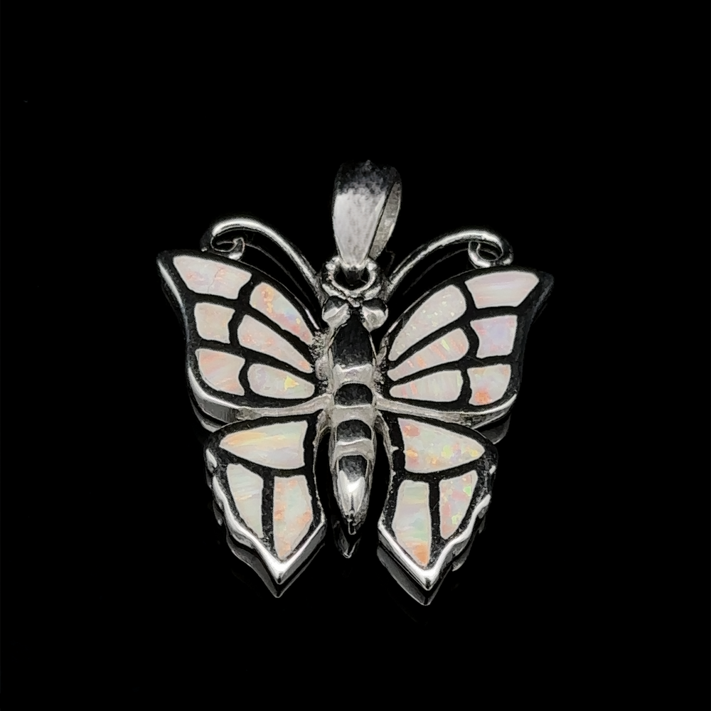 
                  
                    The Lab-Created Opal Butterfly Pendant, exquisitely crafted from sterling silver, showcases iridescent lab-created opal wings set against a sleek black backdrop.
                  
                