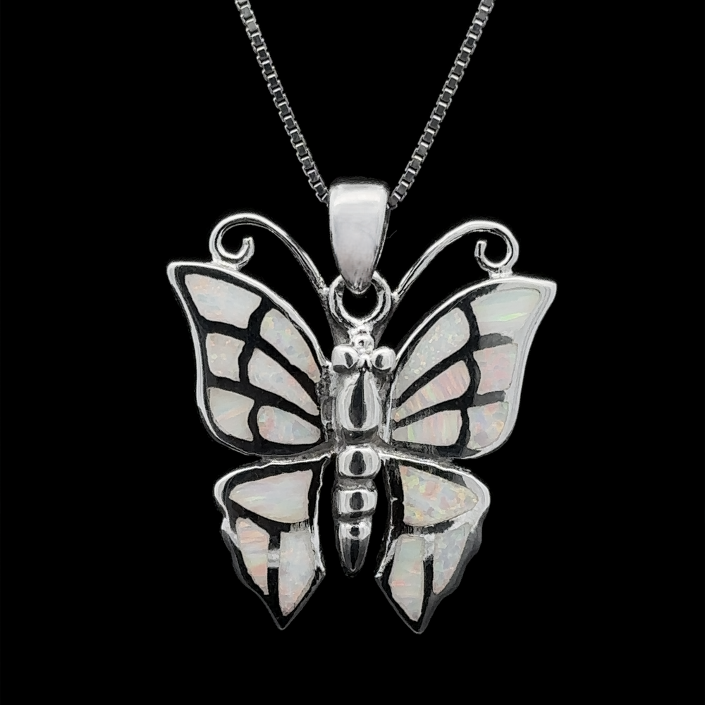 
                  
                    Presenting the Lab-Created Opal Butterfly Pendant, a sterling silver necklace featuring iridescent lab-created opal inlays on butterfly wings, elegantly set against a black background.
                  
                