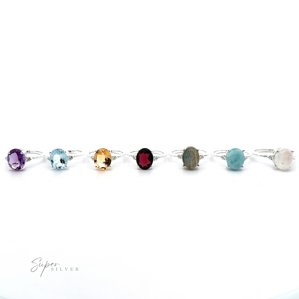 
                  
                    A silver bracelet adorned with various colored gemstones, each set in individual prong settings, against a white background.
                  
                