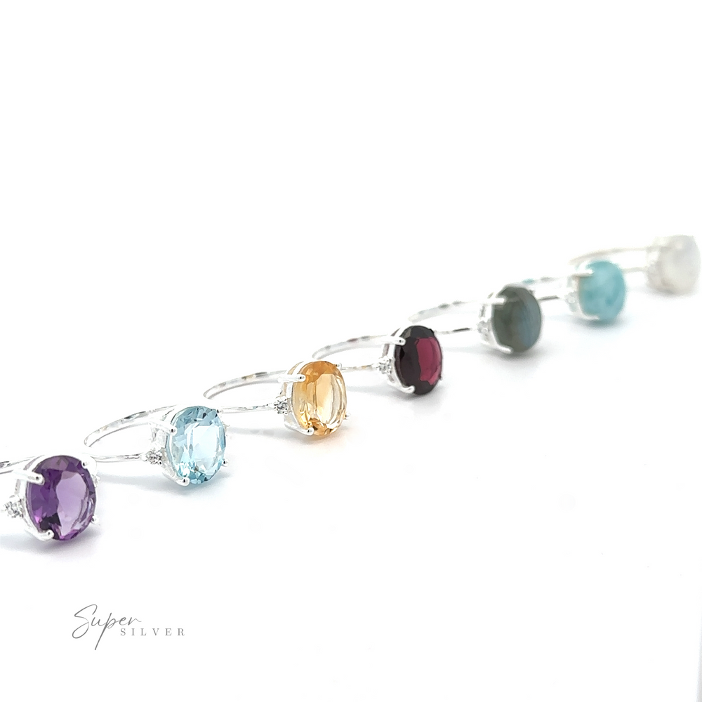 A row of .925 sterling silver bracelets, each featuring a Brilliant Pronged Oval Gemstone Ring, displayed on a white background.