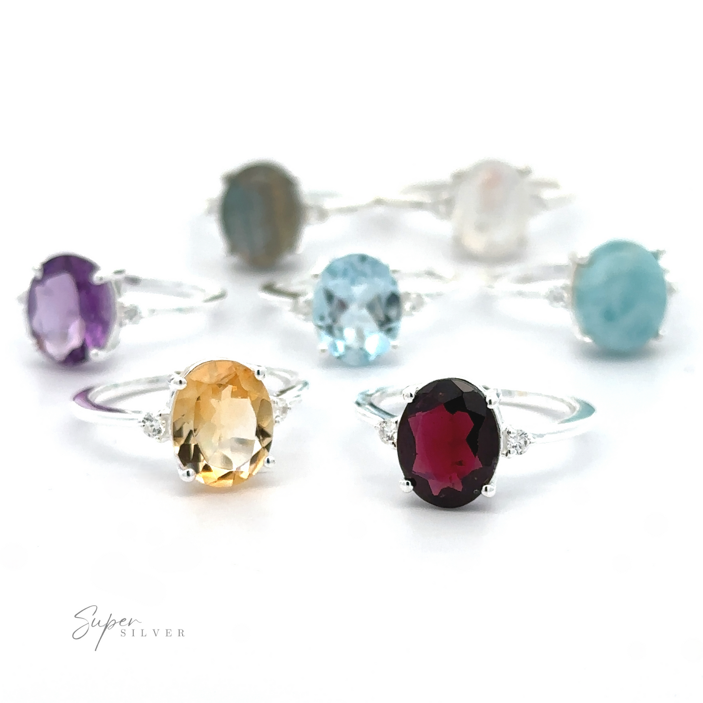 A collection of Brilliant Pronged Oval Gemstone Rings with .925 sterling silver bands displayed against a white background.