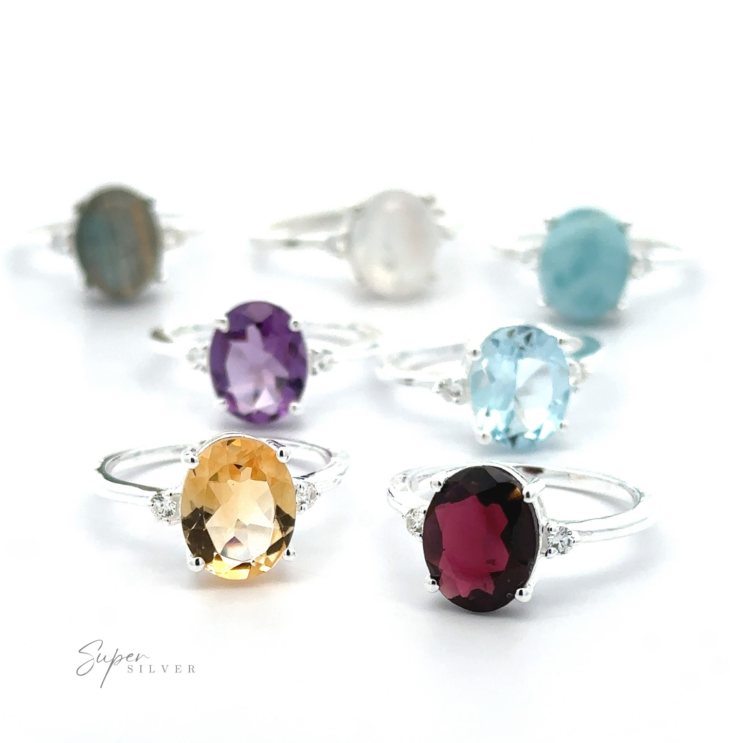
                  
                    A collection of Brilliant Pronged Oval Gemstone Rings with various amethyst, citrine, and topaz gemstones, displayed against a white background.
                  
                