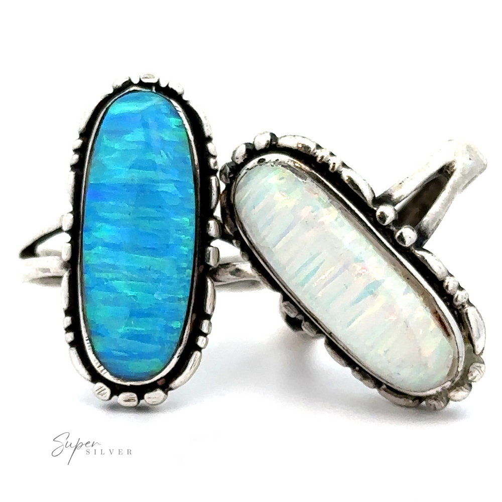 Two **American Made Oval Opal Rings**, one blue and one white. The blue stone has a vibrant, textured pattern, while the white stone has subtle iridescent hues. These Southwestern-styled accessories add a touch of elegance to any ensemble.
