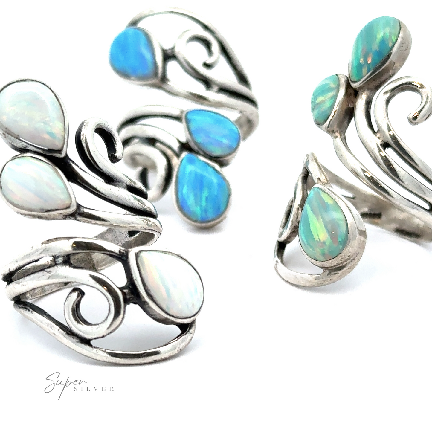 
                  
                    Four Stunning Wrap-Around Opal Rings featuring teardrop-shaped blue and green opal stones arranged in a swirl design on a white background, handcrafted in America.
                  
                