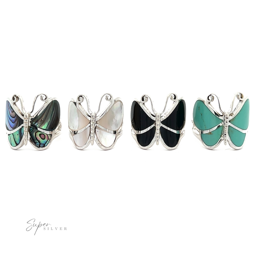 
                  
                    Five Bold Butterfly Rings with Inlaid Stones featuring sterling silver with various inlay patterns, including blue, white, black, and green stones, displayed in a row against a white background.
                  
                
