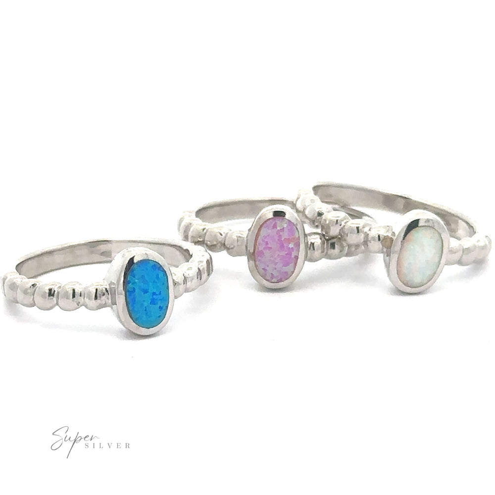Three silver Oval Lab Opal with Beaded Band rings in blue, pink, and white, displayed against a white background.