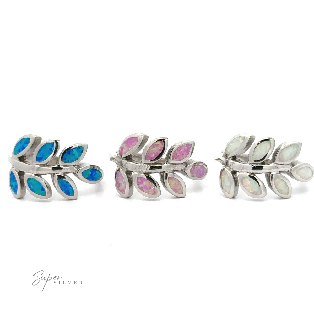
                  
                    Three pairs of fern leaf-shaped sterling silver earrings with different colored lab-created opals on a white background.
                  
                
