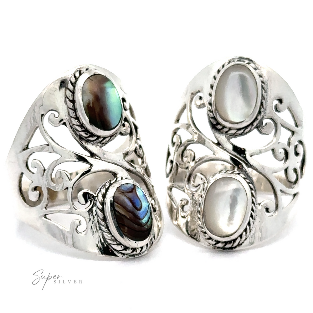 Two ornate silver rings with intricate filigree detailing, each set with an oval gemstone; one features a dark iridescent stone, the other a pearl-like stone. These rings offer a bohemian twist to any ensemble, making them the perfect Boho-Inspired Ring With Inlaid Stones for your collection.