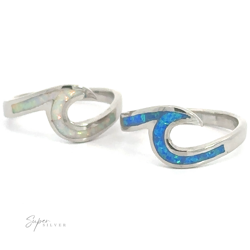 Two silver Wave Rings with Sparkling Inlaid Lab-Opal stones reminiscent of the ocean displayed against a white background.