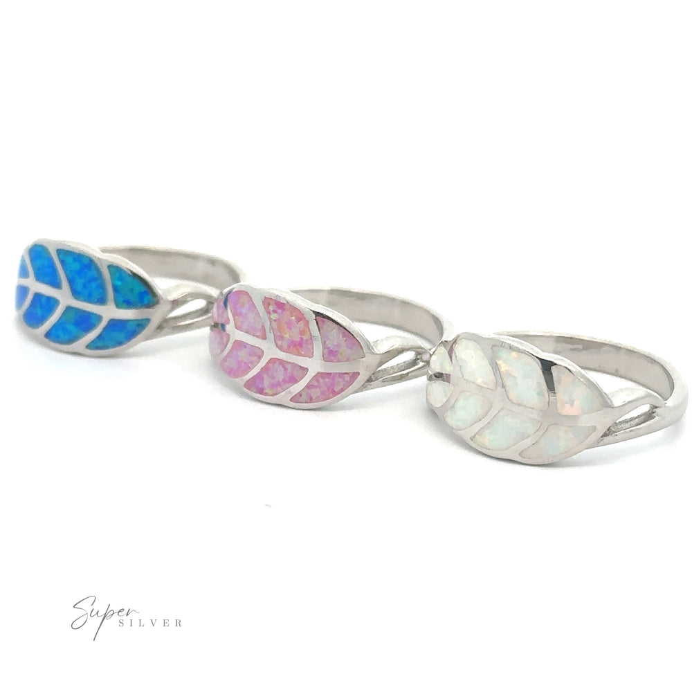 Three Lab Opal Feather rings with inlaid opal gemstones in ethereal shades of blue, pink, and white.