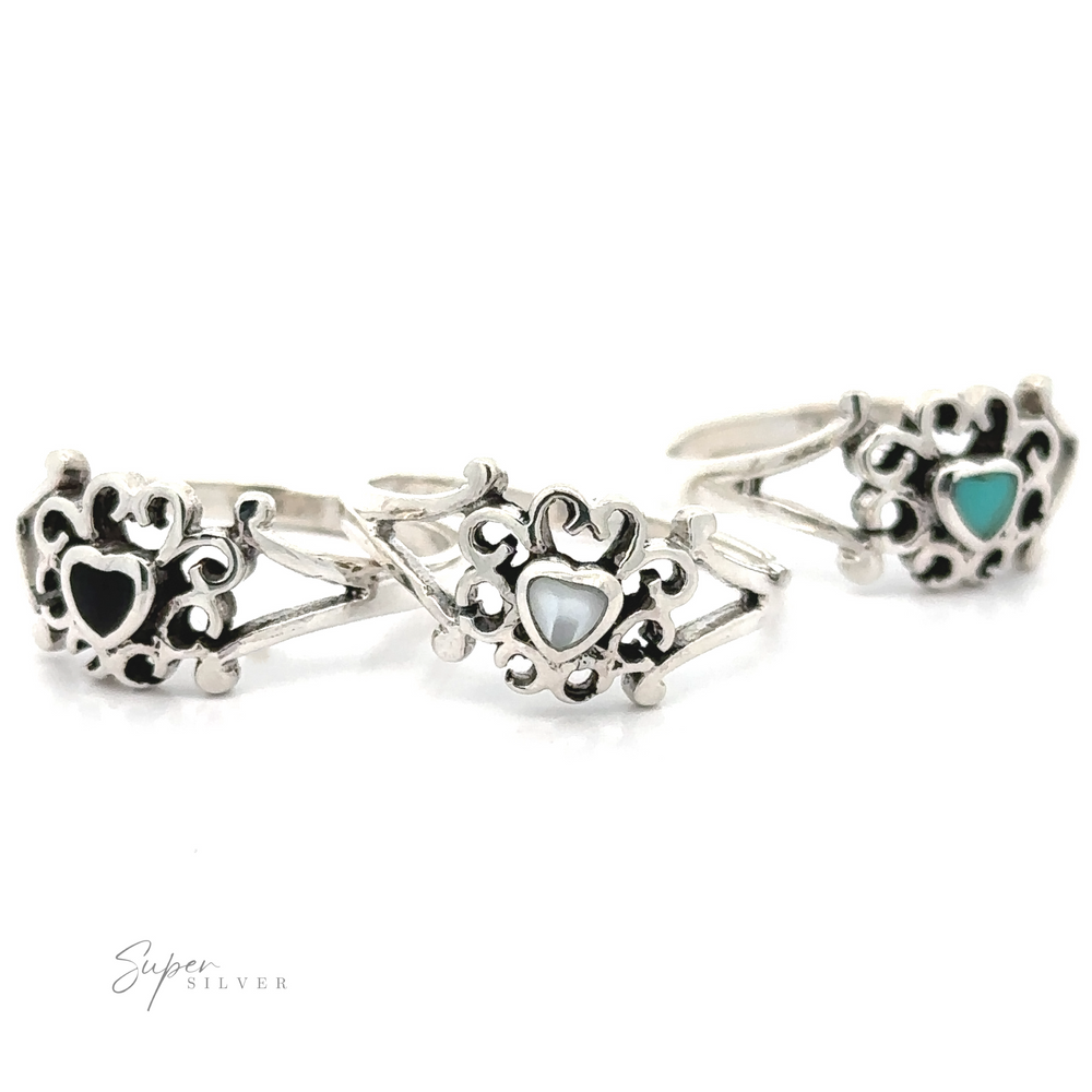 Three Filigree Design Surround Inlaid Stone Heart rings with turquoise stones on them.
