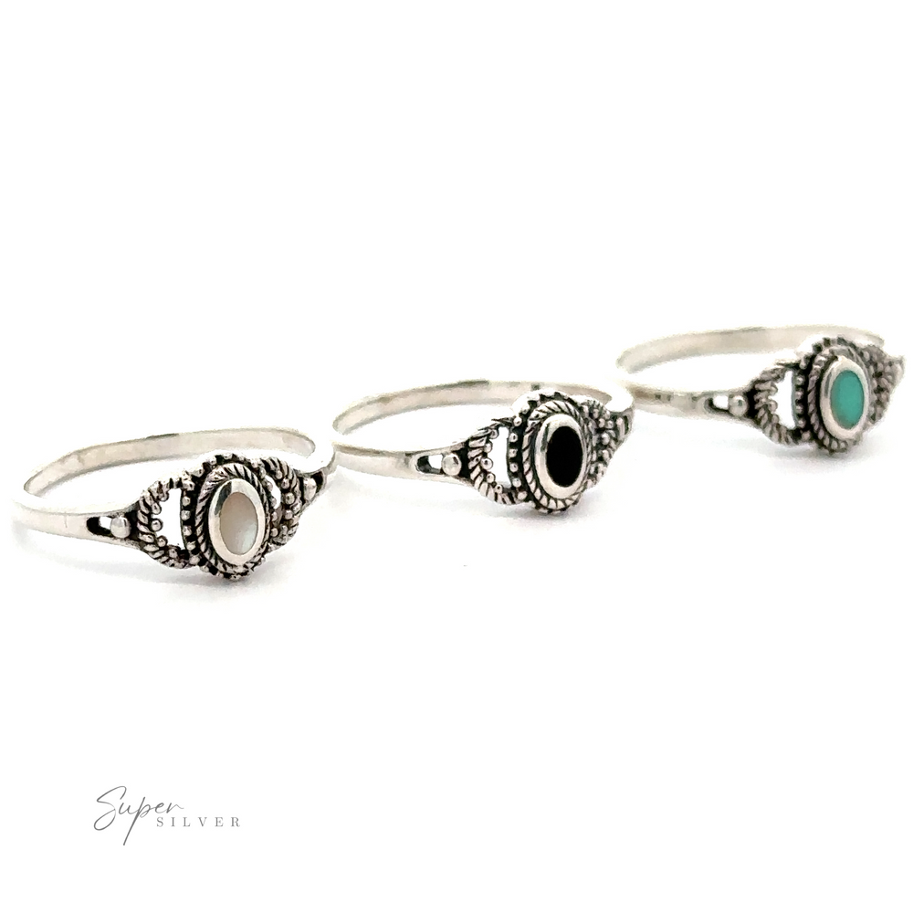 Three vintage silver rings with turquoise and black stones including the Inlaid Oval Stone Ring with Rope Texture.