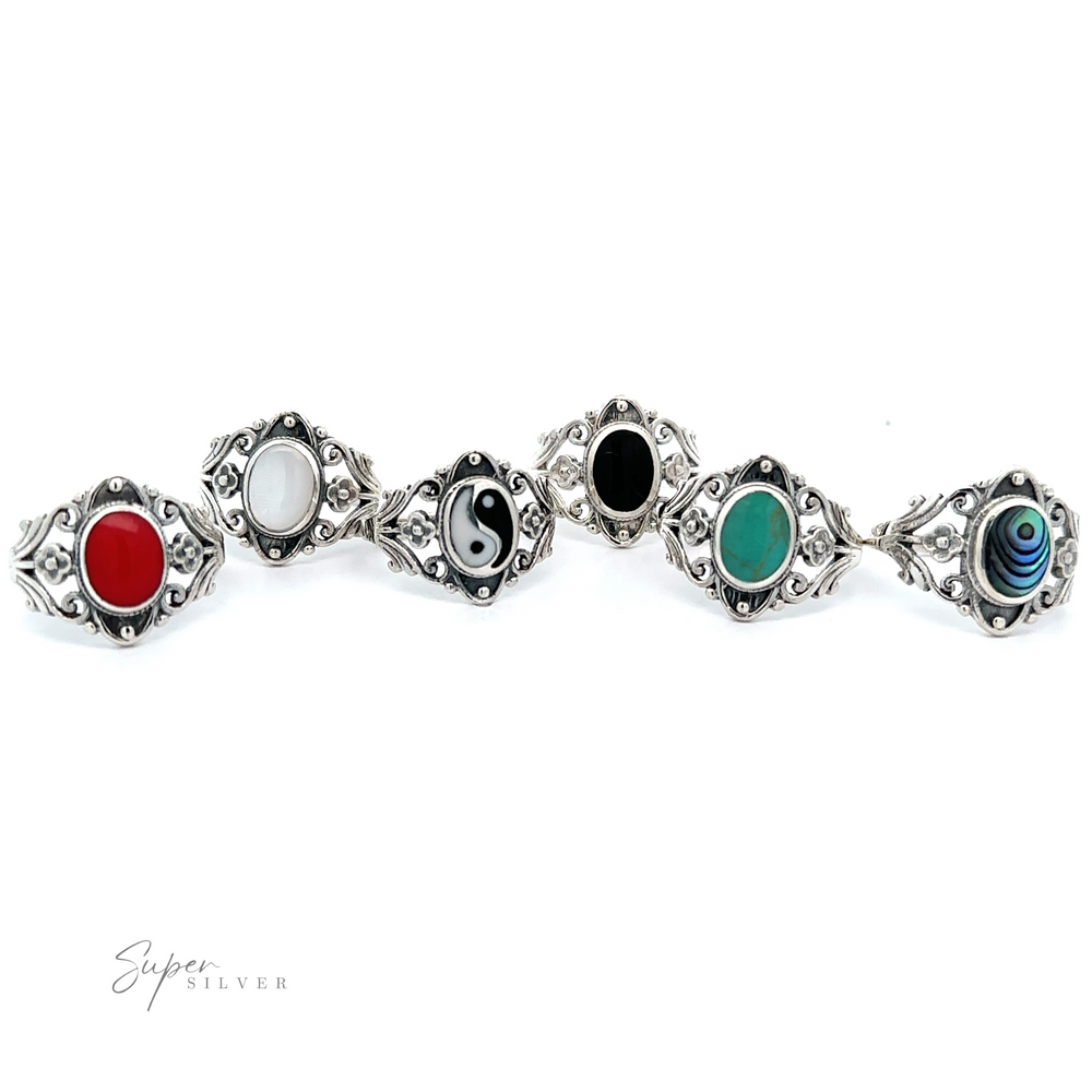 
                  
                    A row of Floral Filigree Inlay Stone Rings with different colors, featuring turquoise and silver filigree.
                  
                