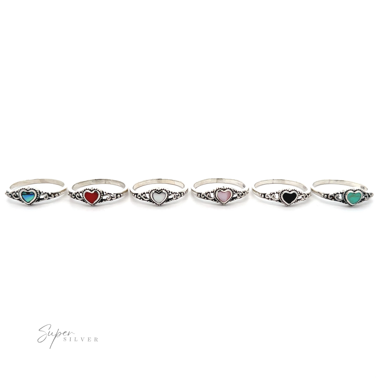
                  
                    A row of Dainty Heart Filigree Rings with Inlaid Stones, each featuring a Bali-style filigree design with different colored stones.
                  
                